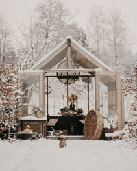 Wooden shed in a snowy landscape with decorative items inside